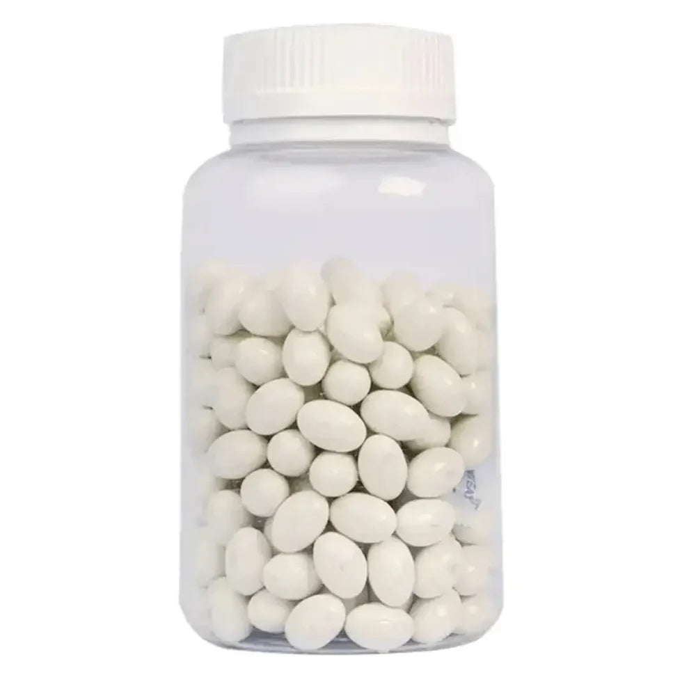 Clear bottle filled with white oval candies on a white background