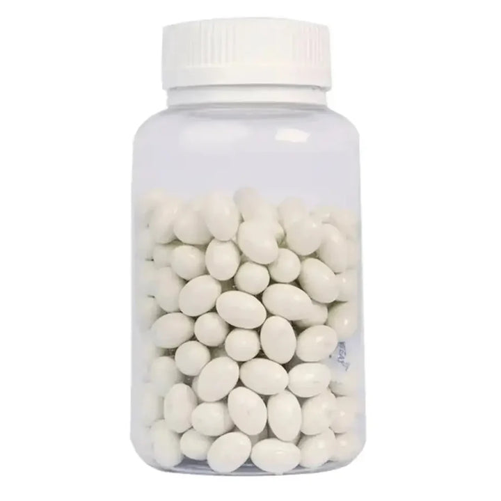 Clear bottle filled with white oval candies on a white background